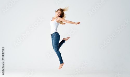 pretty blonde in jeans stands barefoot on the floor isolated background model