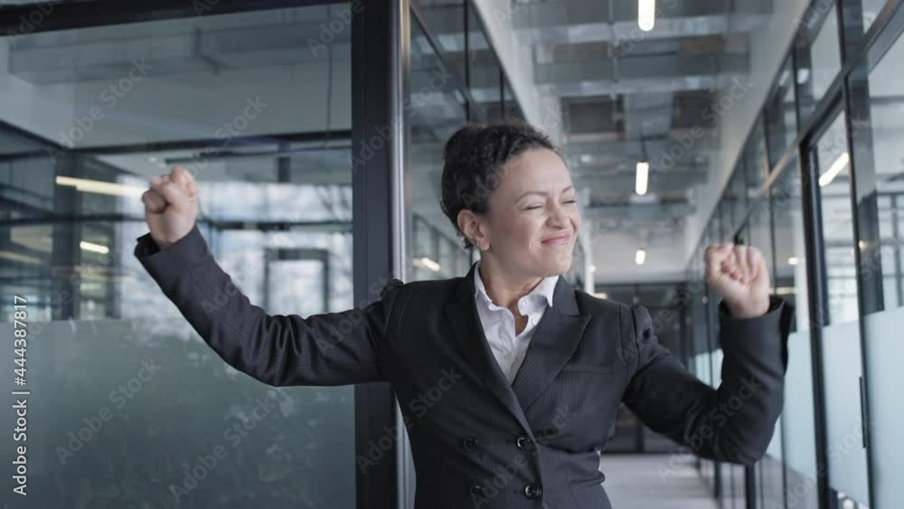 Happy woman in business suit dancing in office slow-mo, celebrating success Happy woman in business suit dancing in office slow-mo, celebrating success