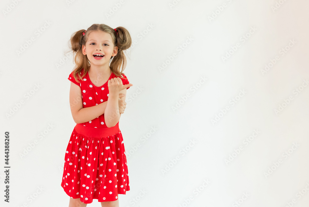 A little girl in a red dress points up at your ad on an isolated white background A little girl in a red dress points up at your ad on an isolated white background