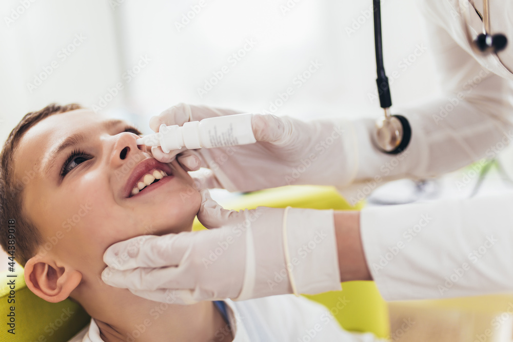 Doctor using nose spray to cure little boy. Doctor using nose spray to cure little boy.