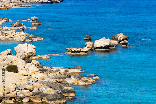Mediterranean sea beach. Stones and Rocks. Summer day seascape. Clear Water texture. Aerial view, sunny day over sea or ocean. Vacation and relax in a secluded place. Nature wallpaper.