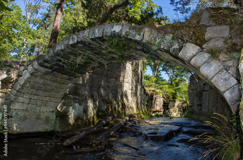 Old stone bridge over a stream in the woods