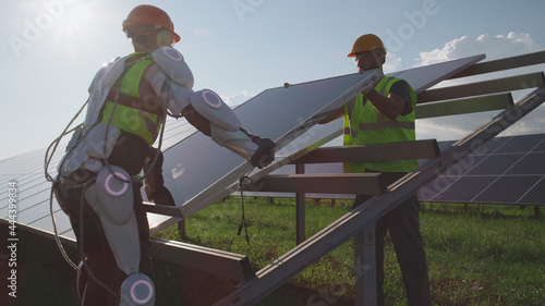 Fotografía Male technicians installing solar cell on sunny day