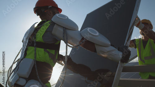 Male technicians installing solar cell on sunny day photo