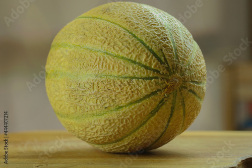Cucumis melo cantalupensis. Melone giallo inntero su sfondo sfocato.