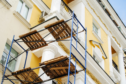 Scaffolding on the background of an old house. Restoration of facades of retro buildings. Foreground