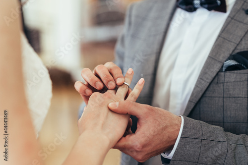 wedding ceremony rings. a man puts a ring on a woman
