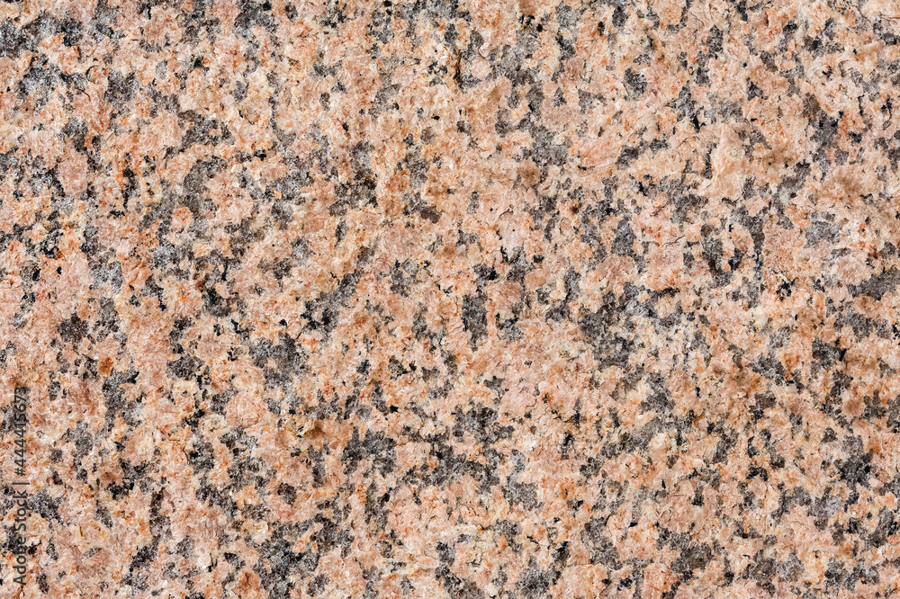 The natural pattern and texture of the red granite surface. Multicolored stone background. The natural pattern and texture of the red granite surface. Multicolored stone background.
