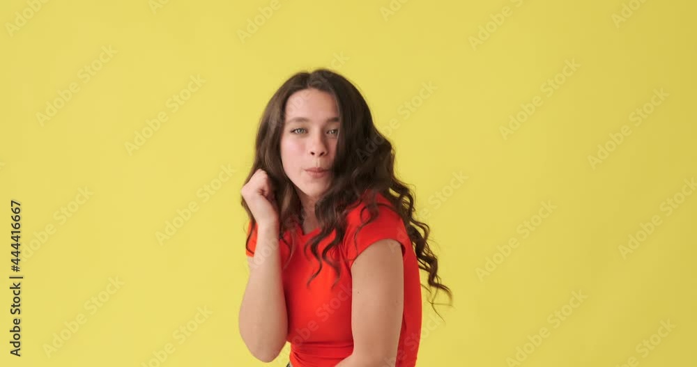 Beautiful woman having fun dancing over yellow background Beautiful woman having fun dancing over yellow background