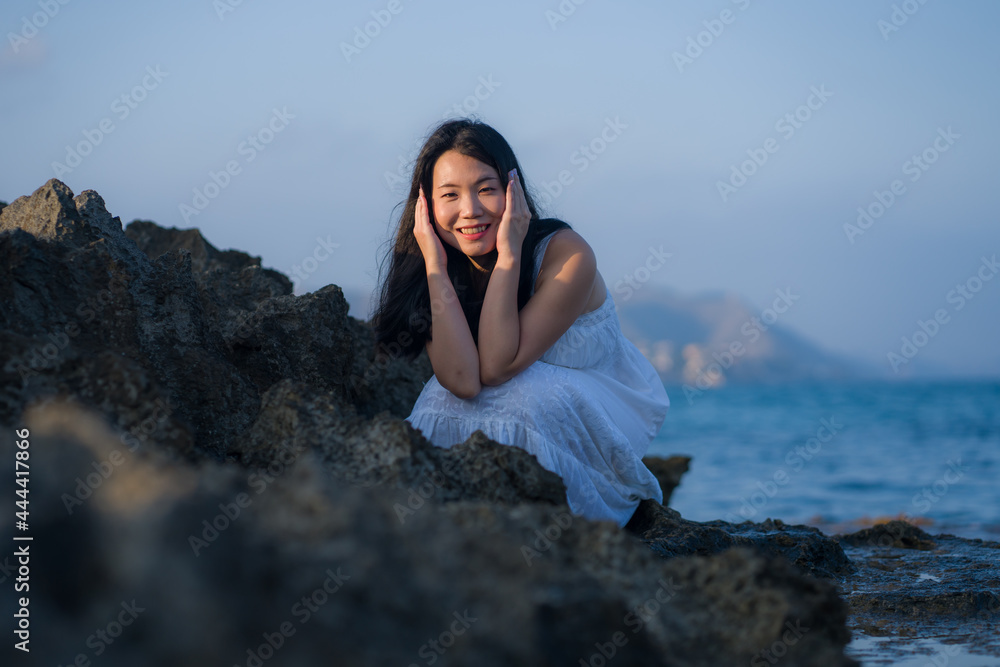 young happy and beautiful Asian woman by the sea - Attractive Japanese girl in white dress enjoying relaxed summer holidays at tropical island in travel and lifestyle concept