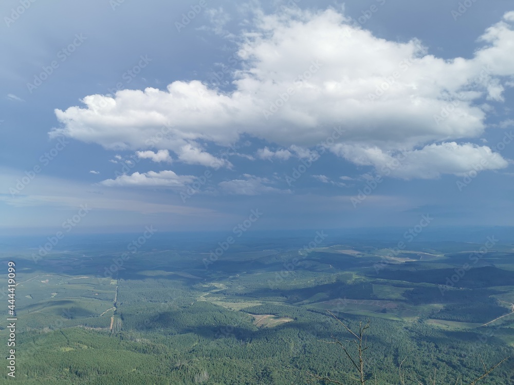 Naklejka premium Green valley blue sky gods window Lush greenery clouds