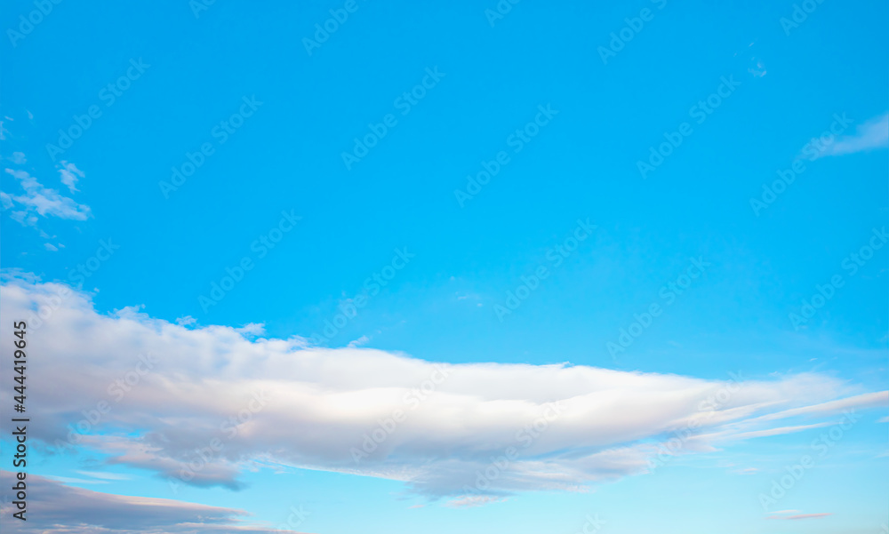 Blue sky and white clouds background - Pillowy clouds cover a blue sky in the background Blue sky and white clouds background - Pillowy clouds cover a blue sky in the background