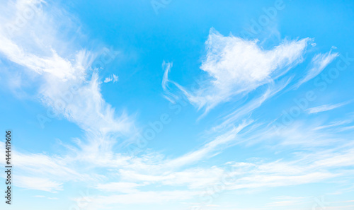 Blue sky and white clouds background - Pillowy clouds cover a blue sky in the background