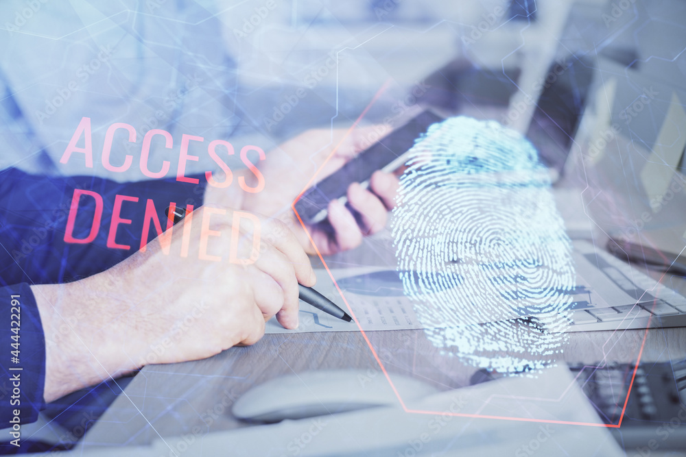 Double exposure of man's hands holding and using a digital device and fingerprint hologram drawing. Security concept. Double exposure of man's hands holding and using a digital device and fingerprint hologram drawing. Security concept.