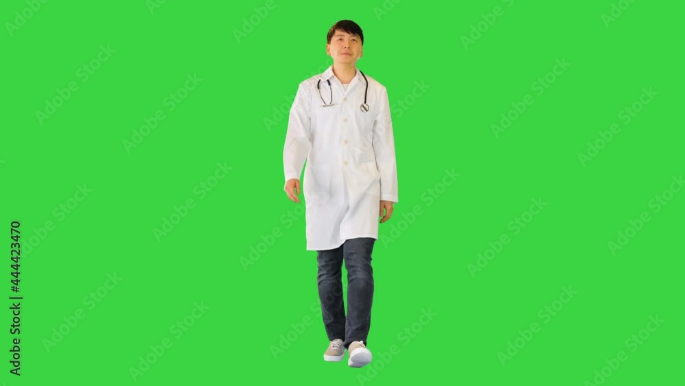 Young asian doctor walks, seemingly tired on a Green Screen, Chroma Key. Young asian doctor walks, seemingly tired on a Green Screen, Chroma Key.