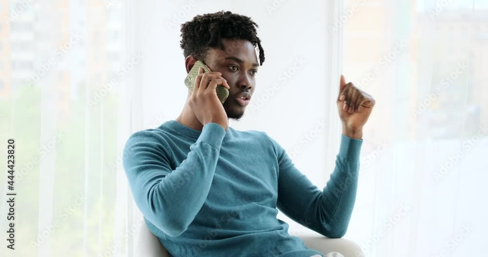 Young African American man talking on mobile phone at home Young African American man talking on mobile phone at home