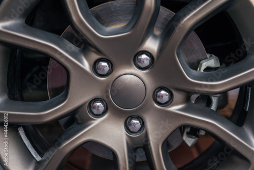 Beautiful alloy wheel close up. Metallic tire rim and disc brake. Detailing series