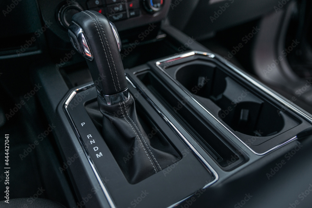 Detail of an automatic gear shifter in a new car close up. Interior of modern car. Luxury and expensive concept. Selective focus