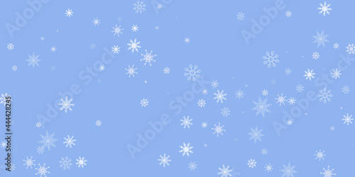 White delicate openwork snowflakes are scattered on a blue background. Festive background, postcard design, wallpaper