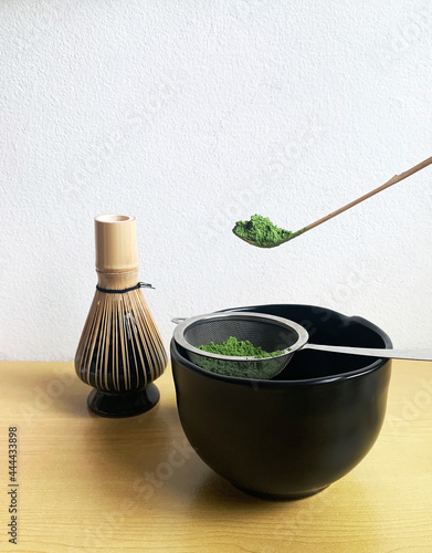 Matcha green tea power with sieve,   Chasen whisk, Chashaku spoon and black bowl, Use a sieve to sift the powder to make the texture fine,  beverage healthy, Matcha green tea ceremon photo