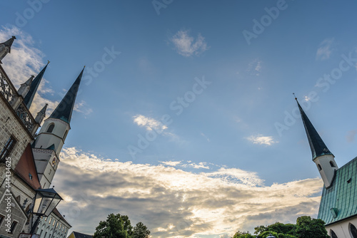 Blick naach oben in nden Himmel mit Türmen der Gnadenkapelle und Stiftspfarrkirche, in Altötting Am Abend im Gegenlicht photo