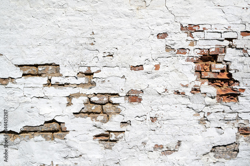 weathered brick wall with crumbling white plaster for background use
