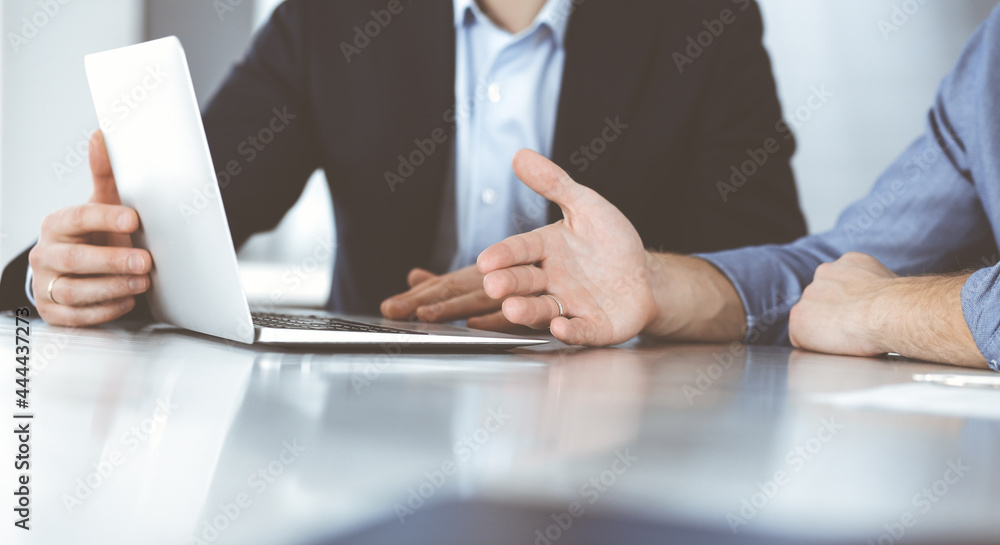 Business people using laptop computer while working together at the desk in modern office. Unknown businessman or male entrepreneur with colleague at workplace. Teamwork and partnership concept Business people using laptop computer while working together at the desk in modern office. Unknown businessman or male entrepreneur with colleague at workplace. Teamwork and partnership concept