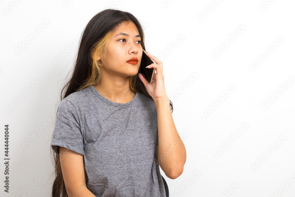 Beautiful young Asian woman smiling sitting relax in the room, using smart phone on white background. Beautiful young Asian woman smiling sitting relax in the room, using smart phone on white background.