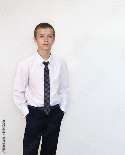 A boy in a white shirt and tie on a light background