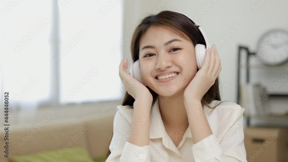 Relaxing time with music. Beautiful young asian woman sitting in the house choose music and take a rest and listening song with wireless headphone. Lifestyle in living room at house in the morning. Relaxing time with music. Beautiful young asian woman sitting in the house choose music and take a rest and listening song with wireless headphone. Lifestyle in living room at house in the morning.