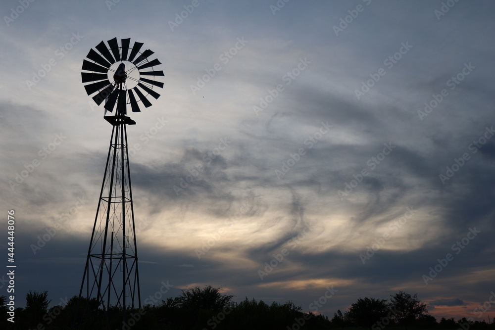 Windmill with sunset and clouds background dark