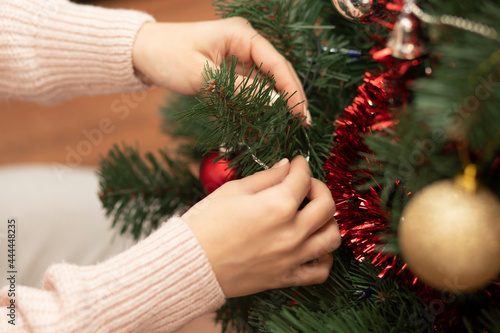 The girl decorates the spruce for the new year and Christmas