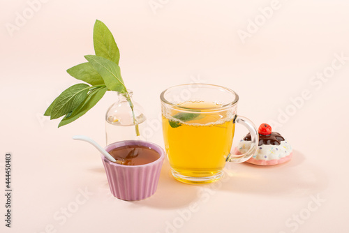Cup of sage herbal tea, fresh sage leaves, honey and lemon.