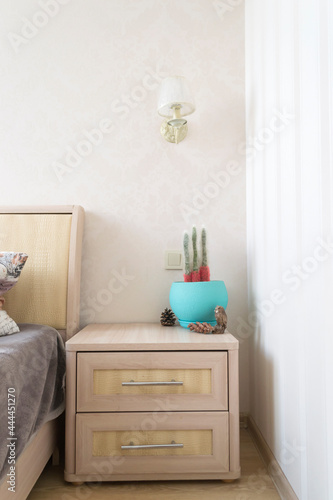 The interior of bedroom. The nightstand with home decor. © Natali Vinokurova