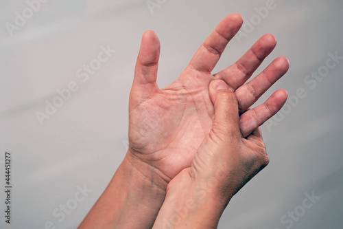 The pain in a female palm. Woman With Painful Hand. Pain and numbness in fingertips and palms photo