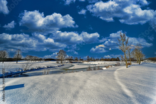Winter landscape pond under a cloudy sky 