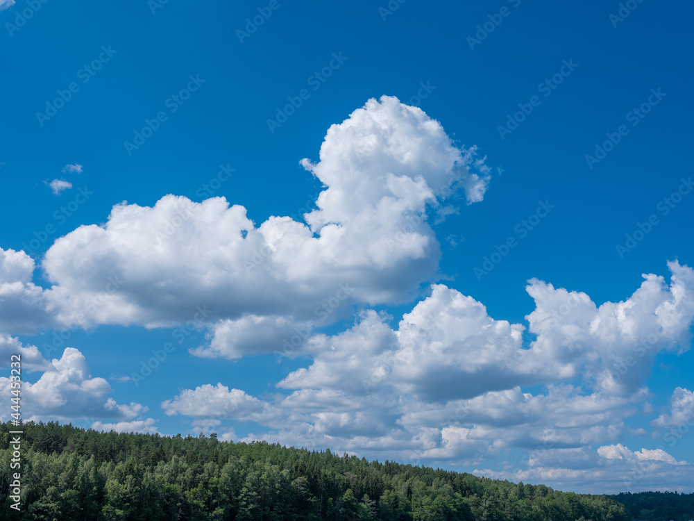 White cloud formation over water and islands covered with trees. Beautiful blue summer sky. Shot in Stockholm archipelago, Sweden, Scandinavia. White cloud formation over water and islands covered with trees. Beautiful blue summer sky. Shot in Stockholm archipelago, Sweden, Scandinavia.