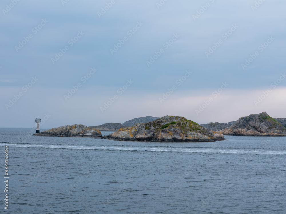 Sea, cliffs and lighthouse on Sweden west coast. Desolate seascape with granite rocks.