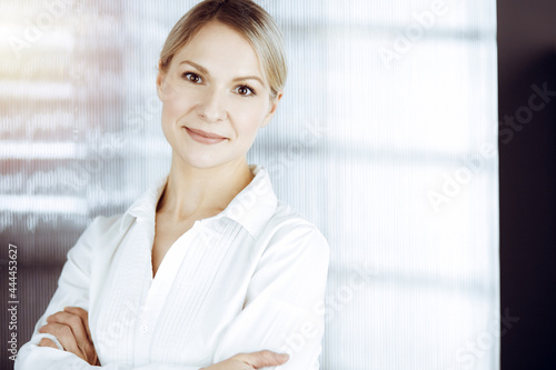 Friendly adult business woman standing straight. Business headshot or portrait in sunny office Free Download Friendly adult business woman standing straight. Business headshot or portrait in sunny office - GFXLoad