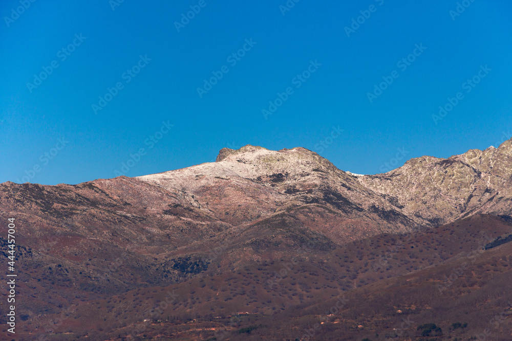 Mountain landscape with snow on the peaks. Winter day with trees without leaves. Gredos Mountain in Spain.