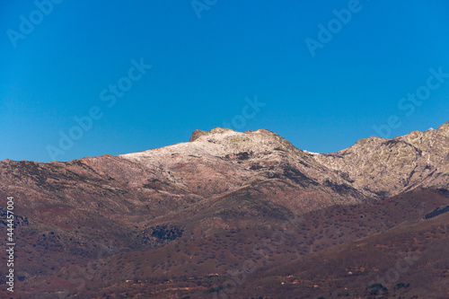 Mountain landscape with snow on the peaks. Winter day with trees without leaves. Gredos Mountain in Spain.