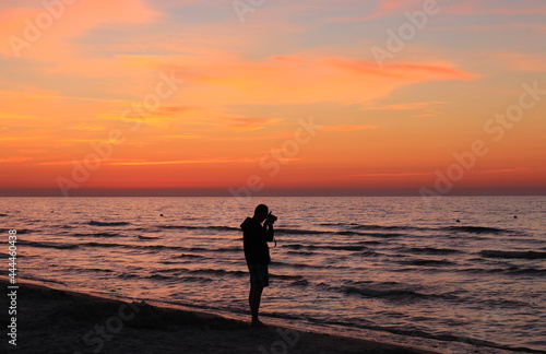 Outline of the photographer's figure cut off from the colourful sky after sunset