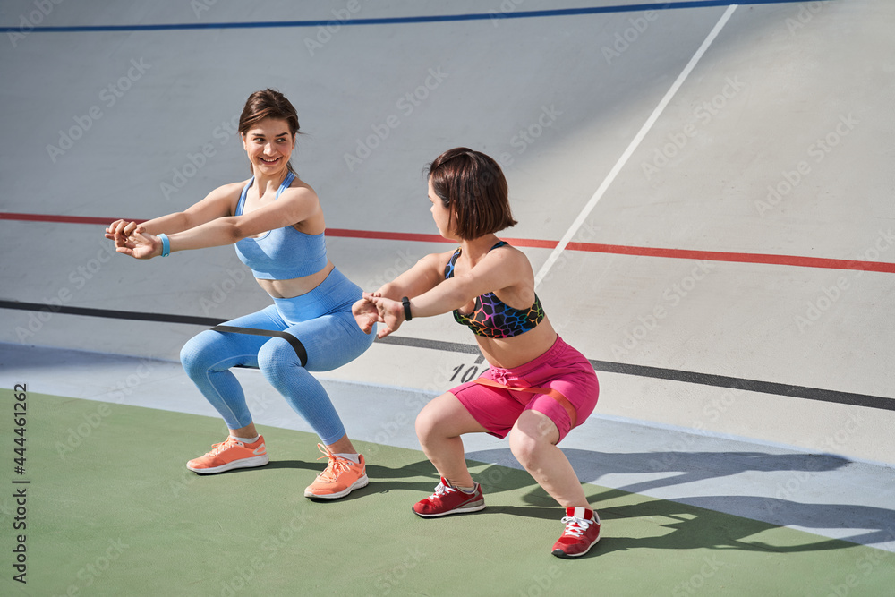 Midget woman wearing sports wear exercising in outdoor arena with her best friend Midget woman wearing sports wear exercising in outdoor arena with her best friend