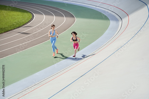 Midget woman running on the stadium with her best friend