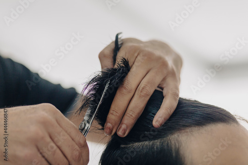 Haircut at a men's barbershop.Haircut with scissors