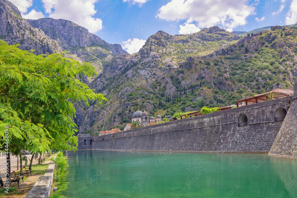 Montenegro, Kotor city. View of Skurda river and northern walls of Old Town of Kotor on summer day Montenegro, Kotor city. View of Skurda river and northern walls of Old Town of Kotor on summer day