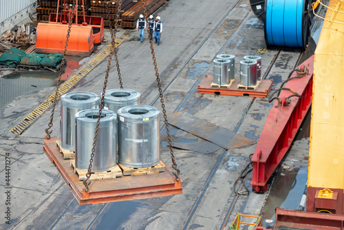 Loading of galvanized steel coils in cargo hold of cargo ship.