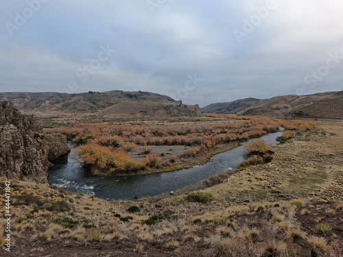 Rural scenery. View of the river flowing across the golden valley  hills and forest in an early autumn morning. Fall s colors in the grass and trees. 