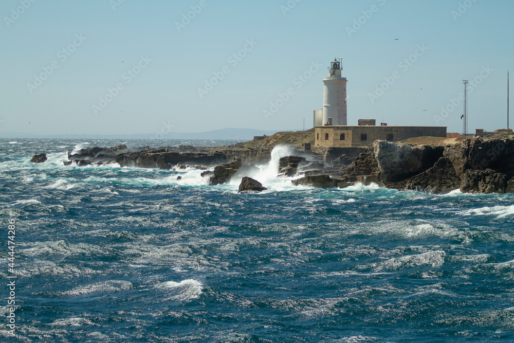 Waters of the Mediterranean sea whipping the breakwater of the Tarifa lighthouse in southern Spain