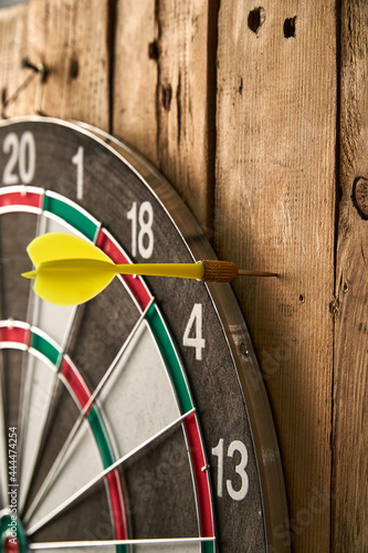 Darts game. Throwing darts at the target. One yellow dart missed the target